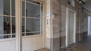 Un pasillo con un amplio ventanal arqueado y una puerta con un cartel encima.