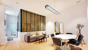 A modern living room with a sofa, coffee table, and dining table with chairs. - Haven of peace near the Palais de Garnier (Paris)