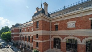 A historic building with red brick facade, arched windows, and classical decorative elements. - Charming studio- 2P- Jardin des plantes/Austerlitz (Paris)
