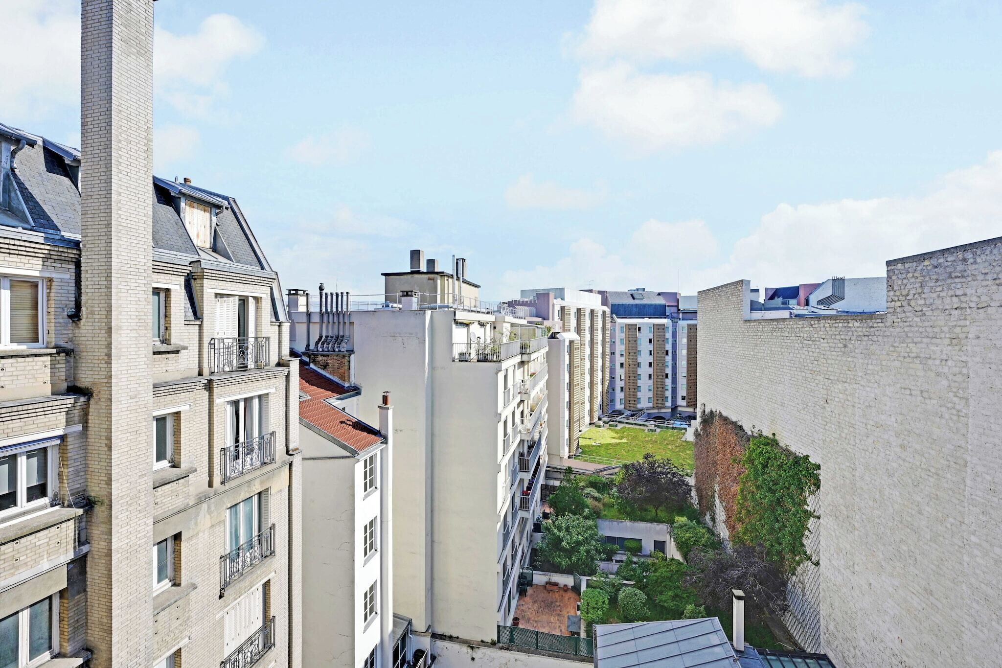 A high-rise building with multiple balconies, a courtyard, and a mix of architectural styles.