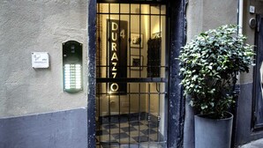Entrada de un edificio con una reja de metal, una planta en maceta y un cartel con el número 4.