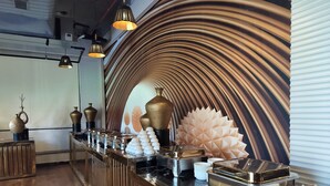 A modern bar area with a curved wall design, a polished marble countertop, and decorative vases. - Hotel Luxe Opera NH8 - 7km from IGI Delhi Airport (New Delhi)