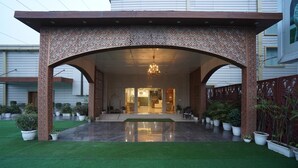 A covered entrance with a reflective floor, potted plants, and a chandelier. - Hotel Luxe Opera NH8 - 7km from IGI Delhi Airport (New Delhi)