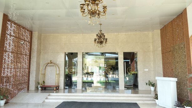 A hotel entrance with a grand chandelier, a reception desk, and a decorative wall. - Hotel Luxe Opera NH8 - 7km from IGI Delhi Airport (New Delhi)