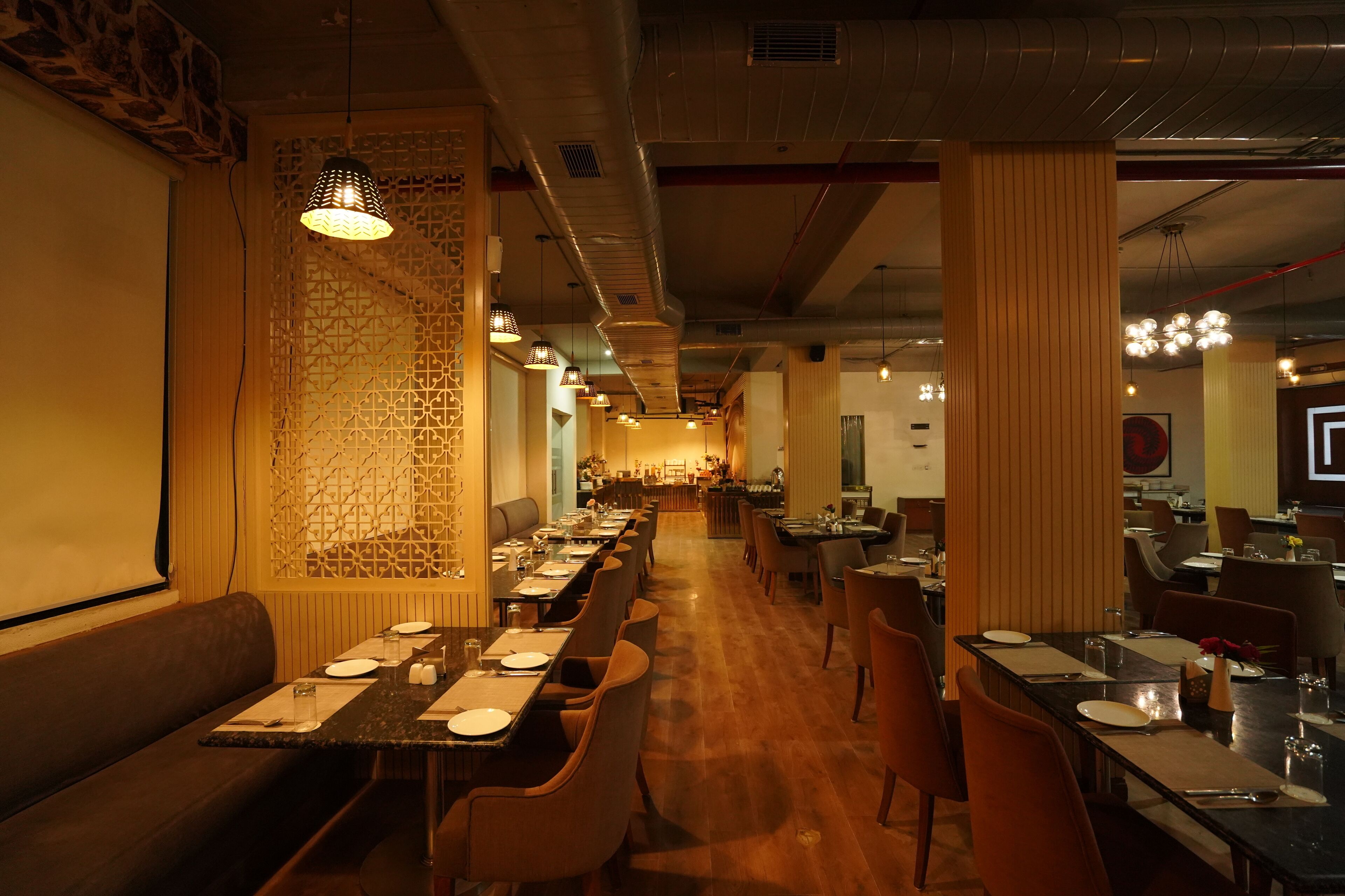 A restaurant with long communal tables, booths, and a bar area.