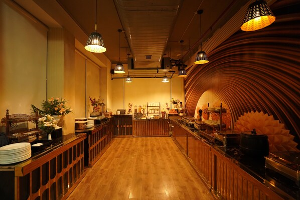 A restaurant with wooden flooring, pendant lighting, and a curved wall design.