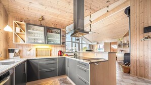Een moderne keuken met houten details, een centraal eiland en inbouwapparatuur.