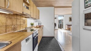 Een moderne keuken met houten kastjes, een roestvrijstalen spoelbak en een zwart aanrecht.