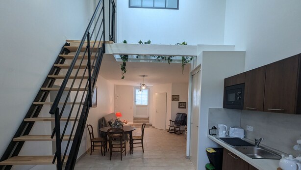 A modern apartment with a staircase, a dining area, and a kitchen. - Gîte 1 Les Ratys: charm, tranquility and comfort near Orleans (Chaingy)
