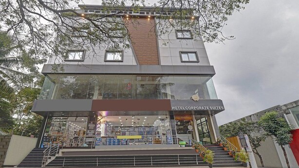 A hotel with a modern design, featuring a glass facade and a staircase leading to the entrance. - Hotel corporate suites (Bengaluru)