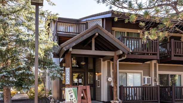 A lodge with a wooden exterior, a balcony, and a sign indicating a room number. - Cozy stay for 4: 5 Min Drive to Base,  Full Kitchen, Shared Hot Tub & Pool, Restaurants Nearby! (Park City)