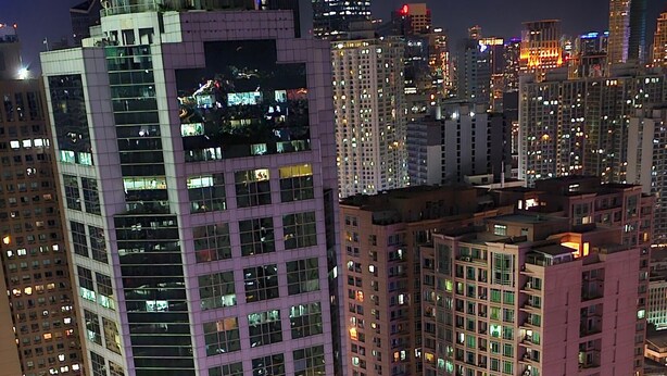 A high-rise building with multiple floors, large windows, and a modern architectural design. - Makati Bliss Apartment - Cozy Urban Retreat (Makati)
