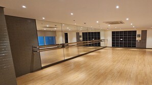 A spacious room with a wooden floor, a mirror, and a wooden railing. - Makati Bliss Apartment - Cozy Urban Retreat (Makati)
