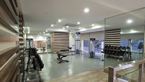 A modern gym with various exercise equipment, including dumbbells and weight machines. - Makati Bliss Apartment - Cozy Urban Retreat (Makati)