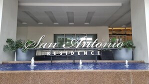 A reception area with a sign reading "San Antonio Residence" and a water feature in front. - Makati Bliss Apartment - Cozy Urban Retreat (Makati)