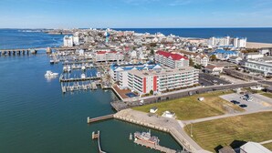 Vista aérea de un pueblo costero con un puerto deportivo, edificios y un muelle.