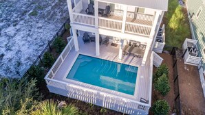 Une maison à deux étages avec une piscine, un balcon et une vue sur l’océan.
