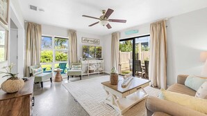 A spacious living room with a ceiling fan, a dining area, and a view of the outdoors. - 3BR Cocoa Beach Oasis | 1 Block to Beach (Cocoa Beach)