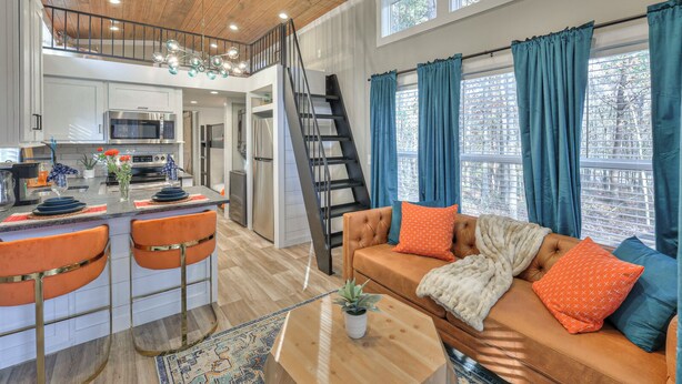 A spacious living area with a sofa, coffee table, and a kitchen with modern appliances.