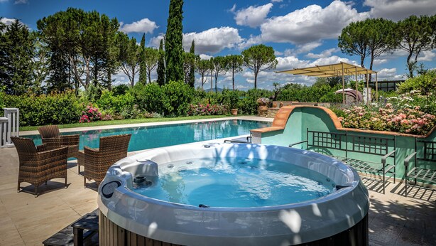 A hot tub, outdoor seating, and a swimming pool surrounded by greenery and trees. - Villa Dei Pavoni - Luxury Villa on top of hills in Florence (Toscana)
