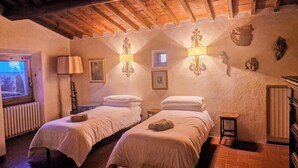 A room with two beds, a window, and a radiator. - Villa Dei Pavoni - Luxury Villa on top of hills in Florence (Toscana)