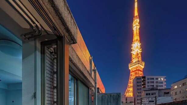 Ein modernes Hotelzimmer mit Blick auf den beleuchteten Tokyo Tower.