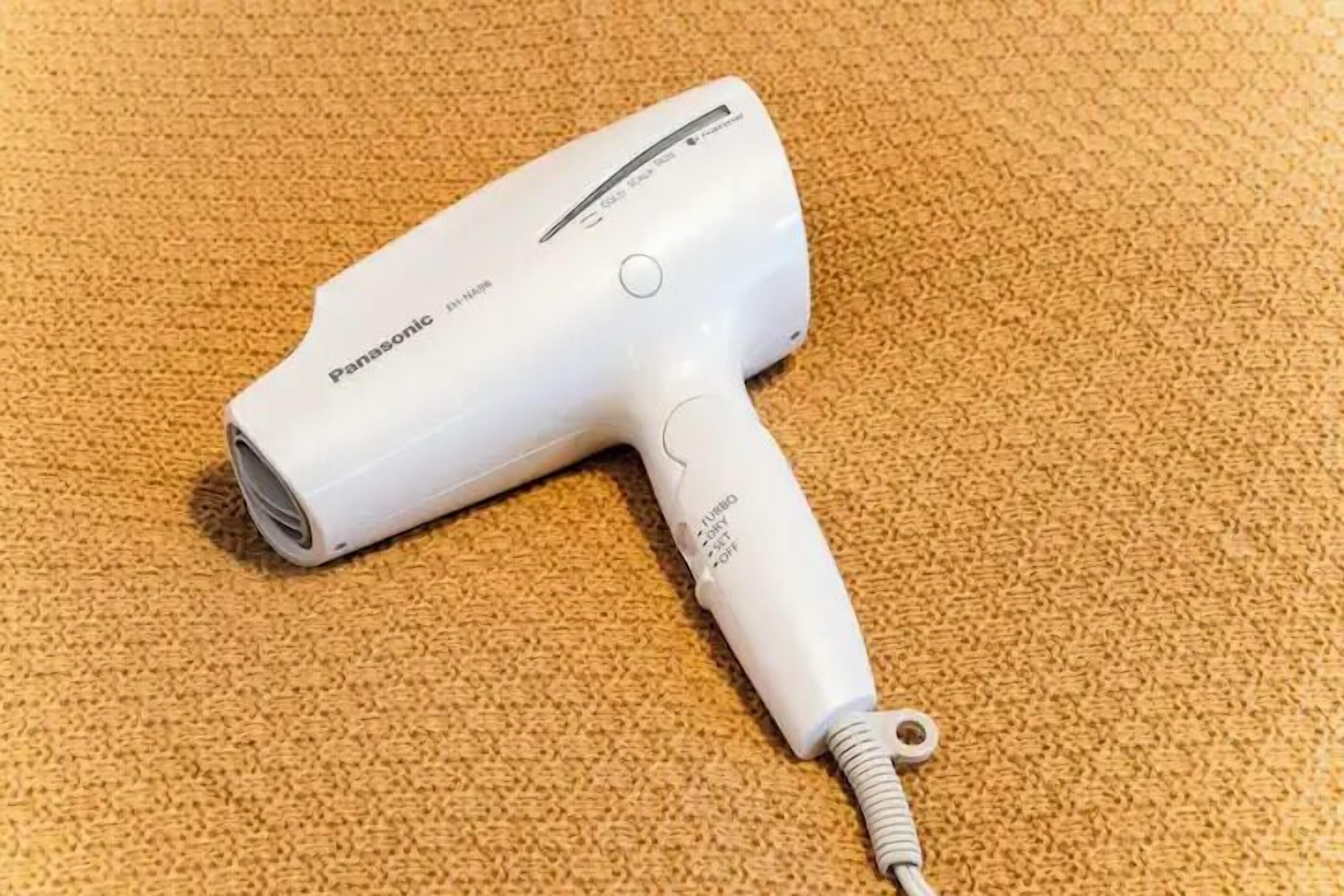Un asciugacapelli Panasonic su un tappeto strutturato.
