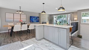 A modern kitchen with grey cabinets, a marble countertop, and pendant lighting. - Chic Kirkland Home Overlooking Windsor Vista Park (Kirkland)