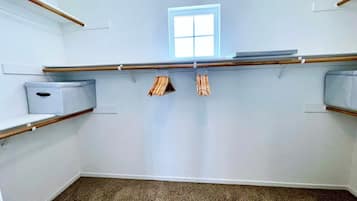 Une pièce avec une fenêtre, deux étagères en bois et une boîte de rangement.