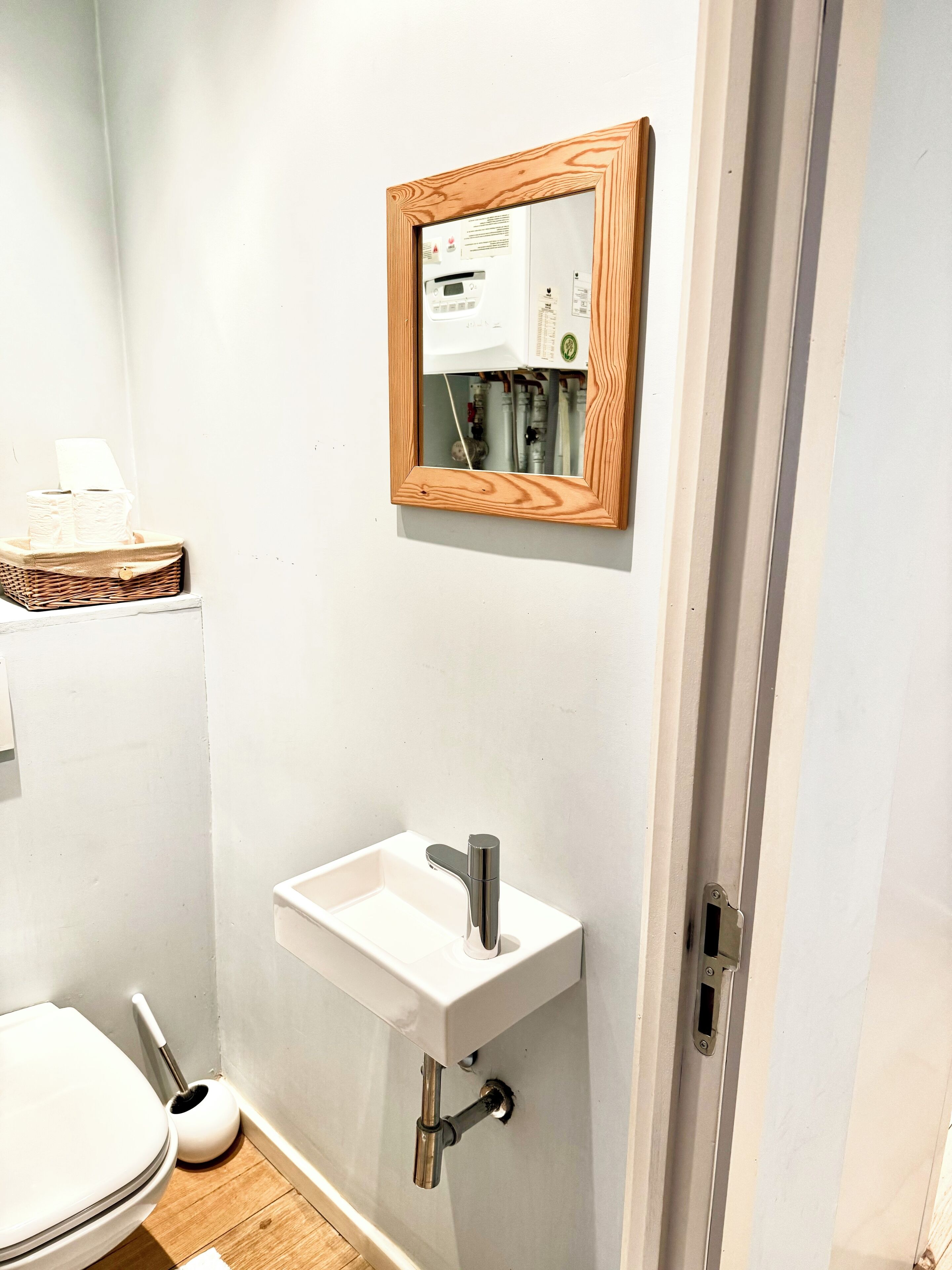 Un baño con un lavamanos blanco, un espejo y un inodoro.
