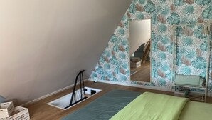 Un dormitorio con cama, espejo y ventana con vista a una escalera.