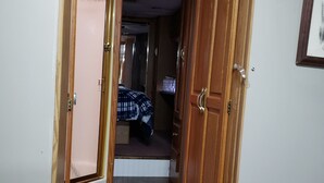 A narrow hallway with wooden doors and a small step leading to a bedroom. - Cozy primitive Rambler RV in Westport Renovo Pa river access  (Renovo)