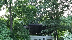 A mobile home in a wooded area with a stone sculpture in the foreground. - Cozy primitive Rambler RV in Westport Renovo Pa river access  (Renovo)