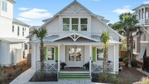 A two-story house with a front porch, green shutters, and a number '42' on the door.