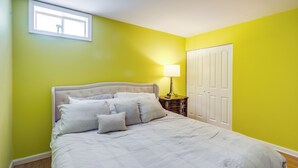 A bedroom with a bed, a nightstand, a lamp, and a wardrobe.