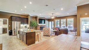 A spacious kitchen with a central island, stainless steel appliances, and a large window providing natural light. - 11 Mi to Dtwn: Lubbock Home w/ Patio, Grill & Yard (Lubbock)