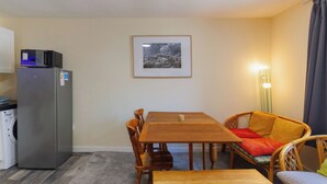 A compact living space with a kitchenette, a dining table with chairs, and a single bed. - Central 2-Bed Flat near Edinburgh’s Highlights (Edinburgh)