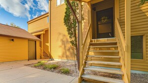 A yellow building with a wooden staircase leading to a door with a wreath. - 7 Mi to Dwtn - Family Condo in Harbor Springs! (Harbor Springs)