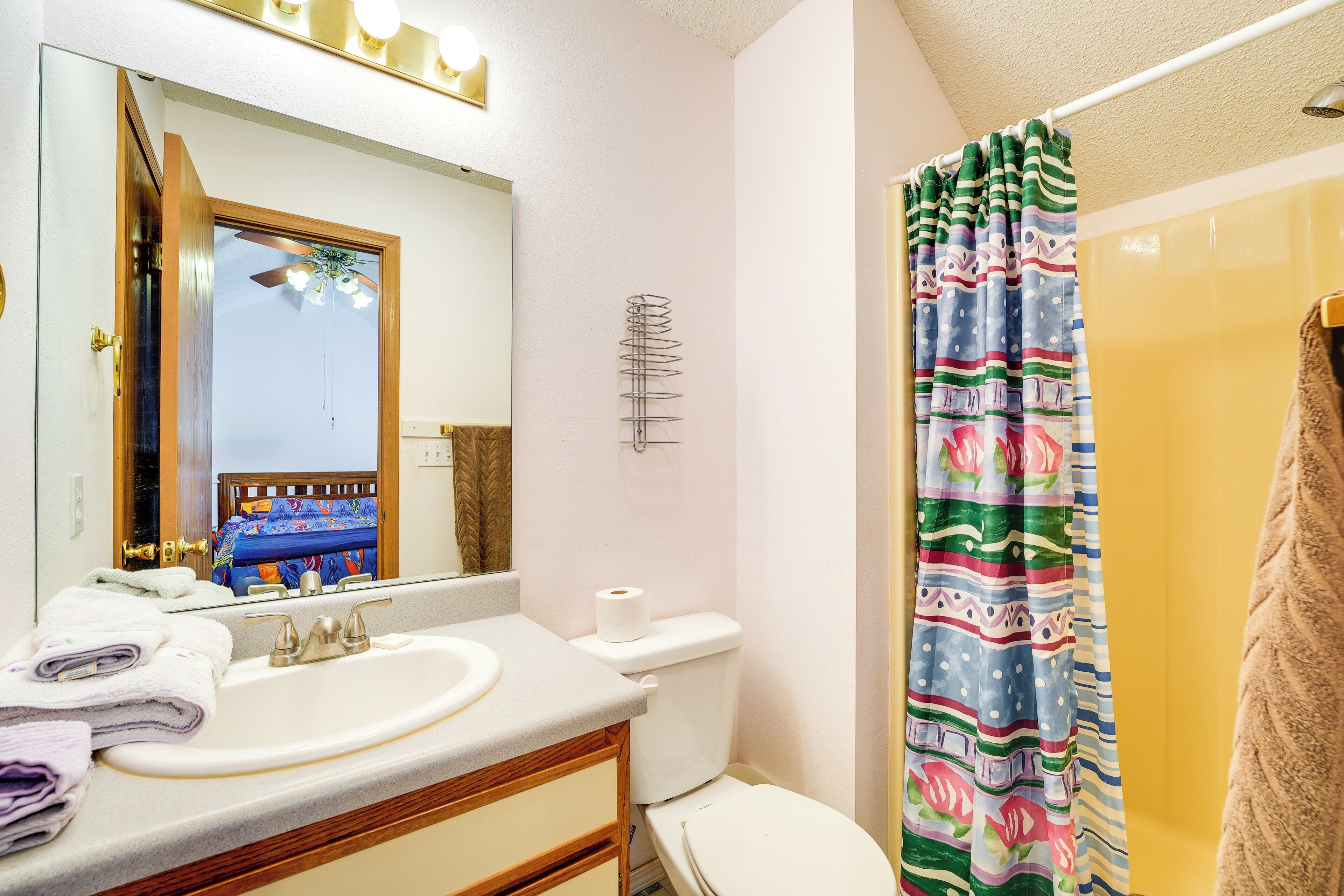 A bathroom with a sink, toilet, and shower curtain.