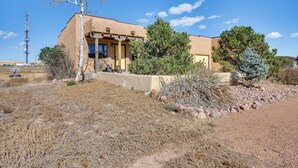 A single-story building with a flat roof, surrounded by dry grass and sparse vegetation. - Mtn Views & Private Courtyard: Home in Pueblo West (Pueblo)