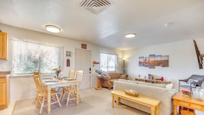 A living room with a dining table, chairs, a sofa, a coffee table, and a TV. - Mtn Views & Private Courtyard: Home in Pueblo West (Pueblo)
