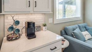 A kitchen with white cabinets, a coffee maker, and a window with blinds. - Deck, Grill & Fishing Pond: Modern Cookeville Gem (Cookeville)