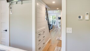 A bedroom with a bed, a dresser, and a staircase leading to another room. - Deck, Grill & Fishing Pond: Modern Cookeville Gem (Cookeville)