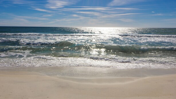 Una playa con olas y cielo despejado.