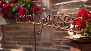 A wrought iron sign with the words "Welcome to Gasse" mounted on a metal structure. - Weinhof Gassen (Kröv)