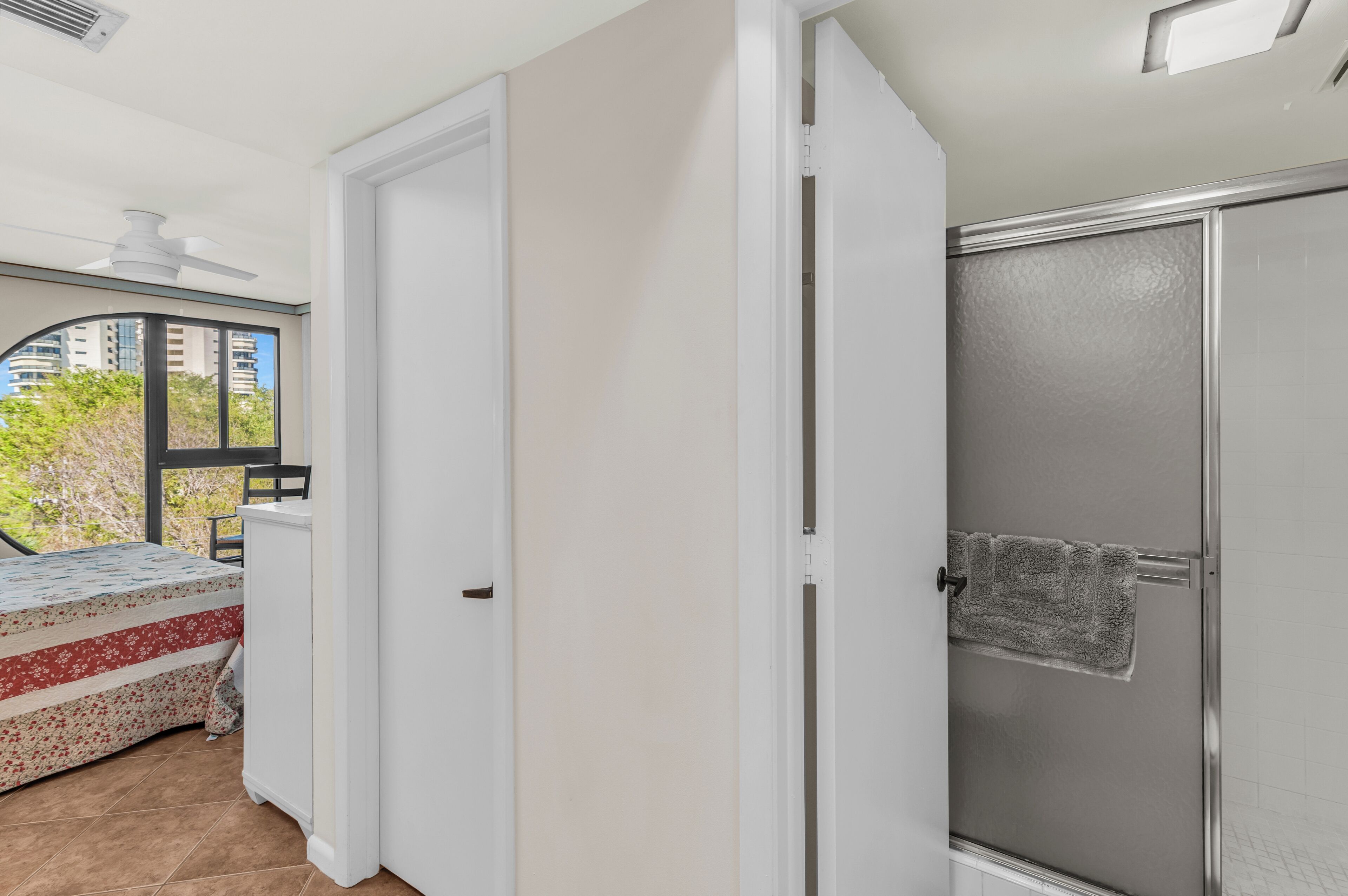 A room with a bed, a door, and a shower area.