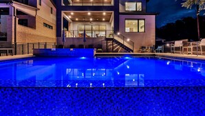 A modern building with a swimming pool, featuring a multi-level design with glass windows and a staircase leading to the upper levels. - Cadillac on the Colorado | Concierge Services (Kingsland)