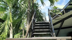 Eine Treppe führt zu einem Gebäude, das von Palmen umgeben ist.