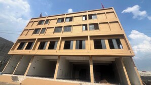 A multi-story building with a flat facade, multiple windows, and a construction site at the base. - Hotel Lotus (Botad)