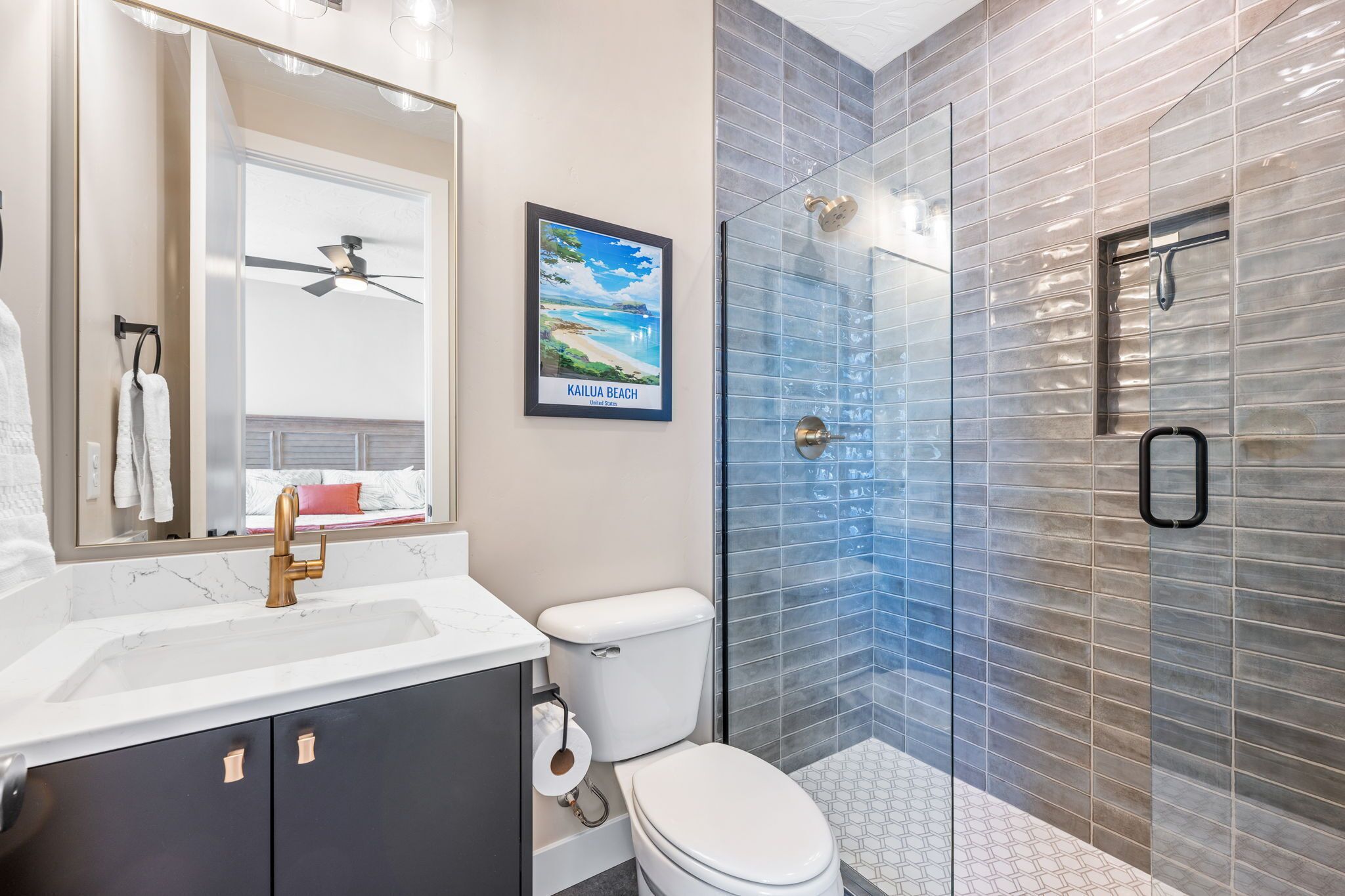 Un baño moderno con lavamanos de mármol, inodoro y cabina de ducha de vidrio.